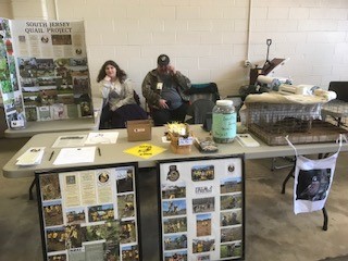 Two people sitting behind a table that is covered with photos